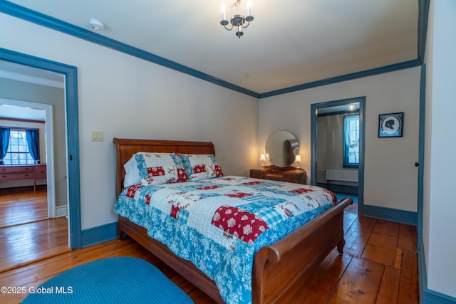 bedroom with crown molding, baseboards, and wood-type flooring