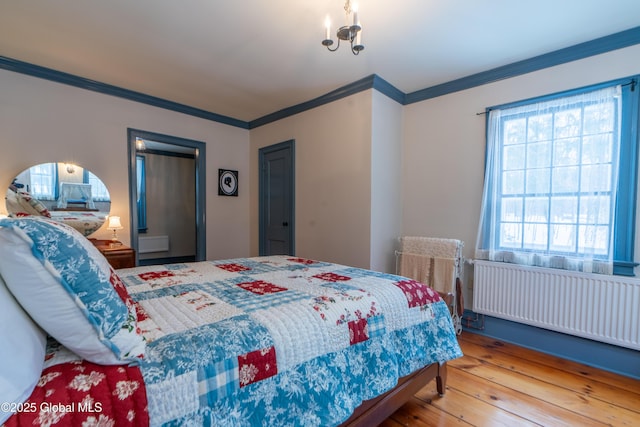 bedroom with radiator, ornamental molding, and hardwood / wood-style flooring