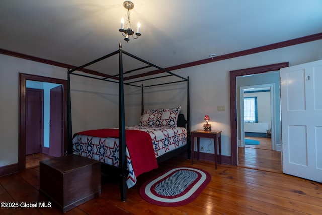 bedroom with hardwood / wood-style flooring, crown molding, and baseboards