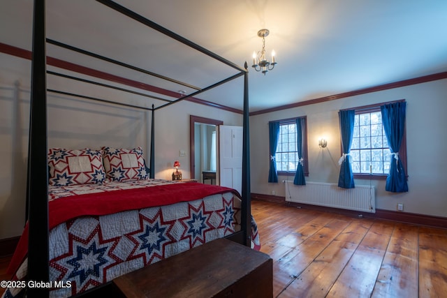 bedroom with baseboards, an inviting chandelier, radiator heating unit, hardwood / wood-style flooring, and crown molding