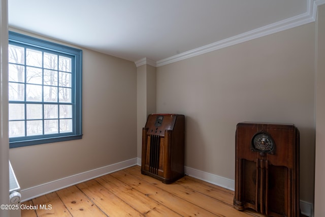 unfurnished room featuring crown molding, baseboards, and light wood-type flooring