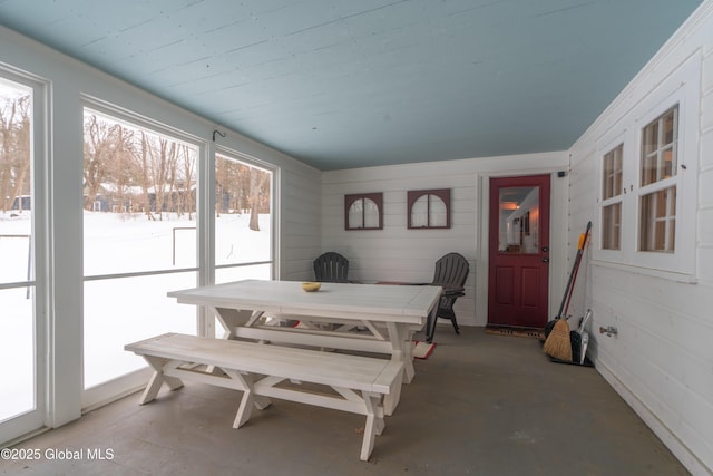 dining space with concrete flooring and a sunroom