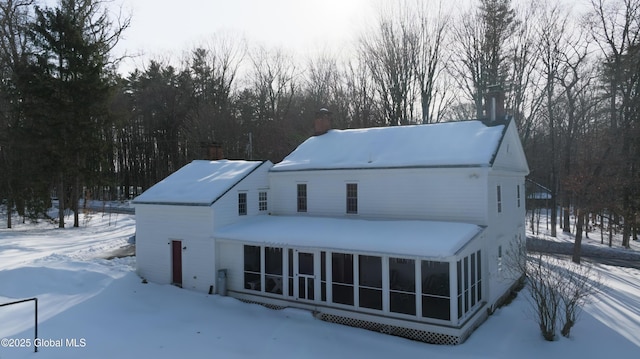 view of front of property featuring a chimney and a sunroom