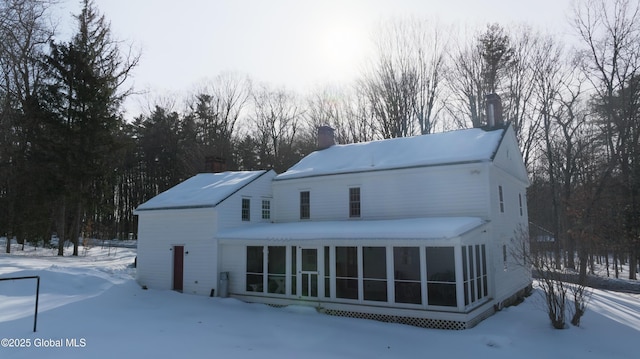 view of front of home with a chimney and a sunroom