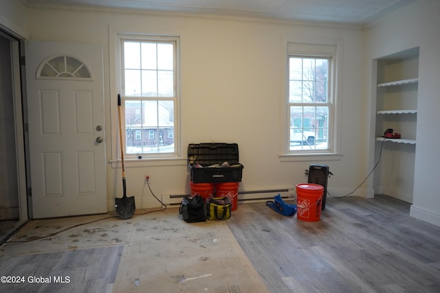 foyer entrance with ornamental molding, a wealth of natural light, and wood finished floors