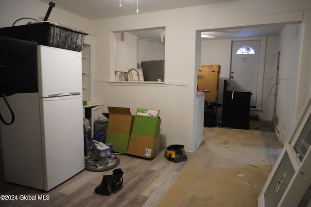 interior space with light wood finished floors, fridge, and freestanding refrigerator