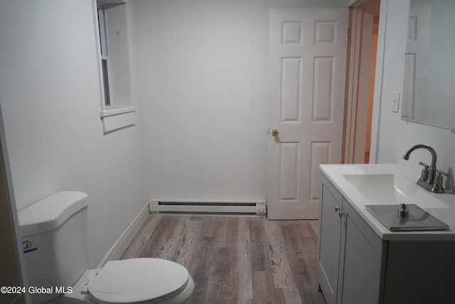 bathroom featuring a baseboard radiator, toilet, vanity, wood finished floors, and baseboards