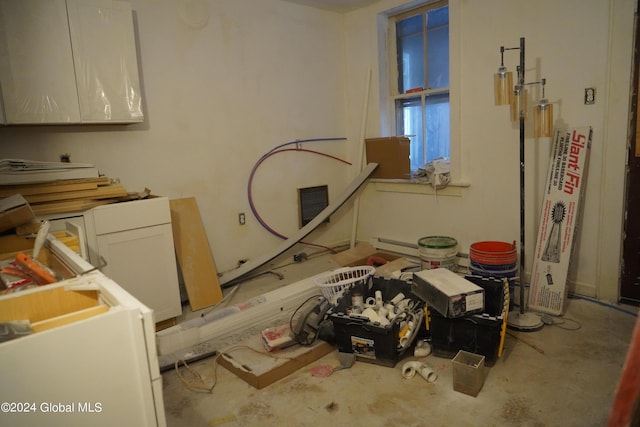 interior space with a baseboard heating unit, visible vents, and unfinished concrete floors