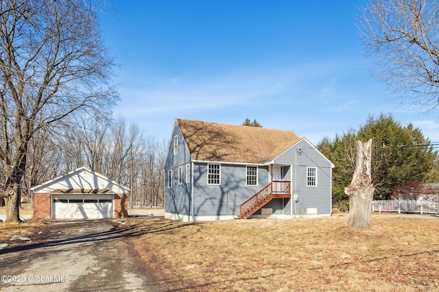 view of front of property with a garage, a front yard, fence, and an outdoor structure