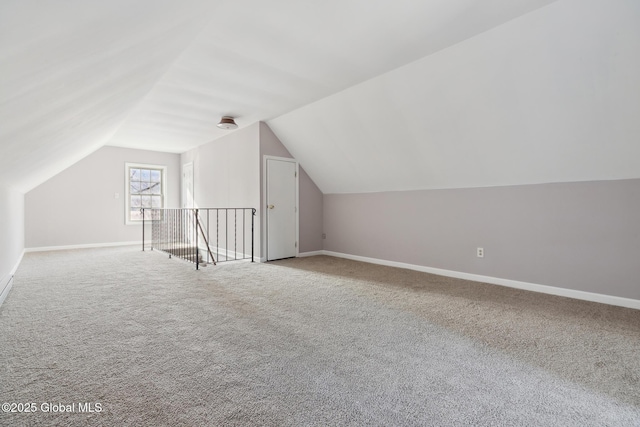 additional living space with baseboards, vaulted ceiling, and carpet flooring