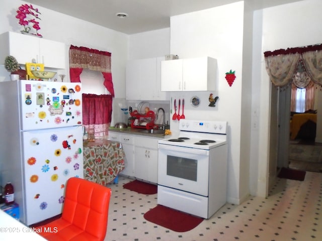 kitchen featuring a sink, white appliances, white cabinets, and light floors