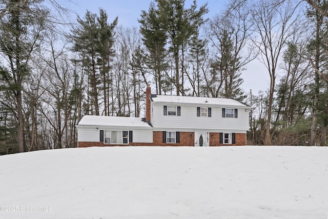 colonial-style house with brick siding and a chimney