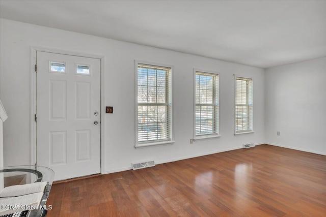 entryway featuring baseboards, visible vents, and wood finished floors