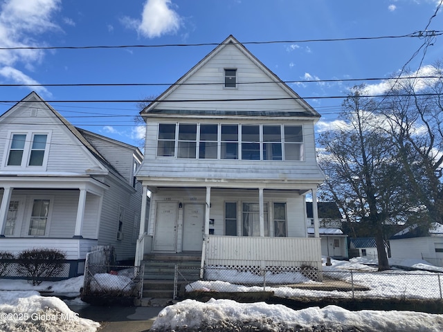 view of front of property with a porch and fence