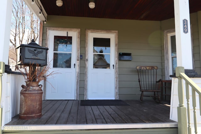 entrance to property with a porch and a standing seam roof