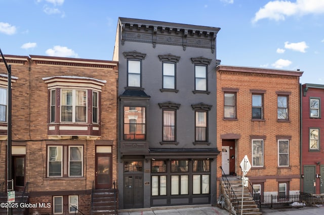 townhome / multi-family property featuring concrete driveway and brick siding