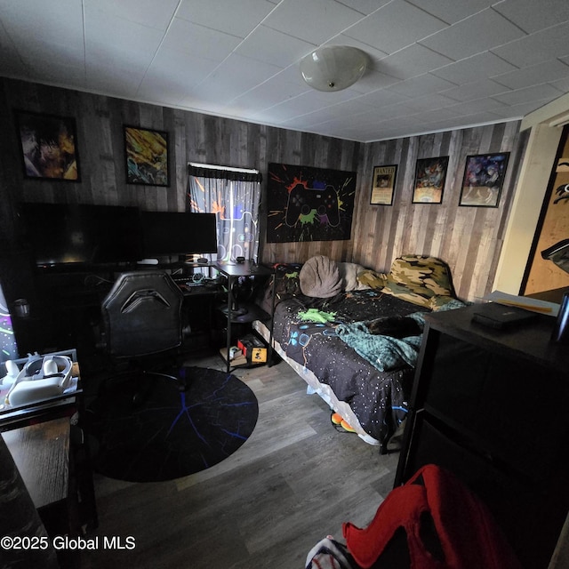 bedroom featuring wood walls and wood finished floors