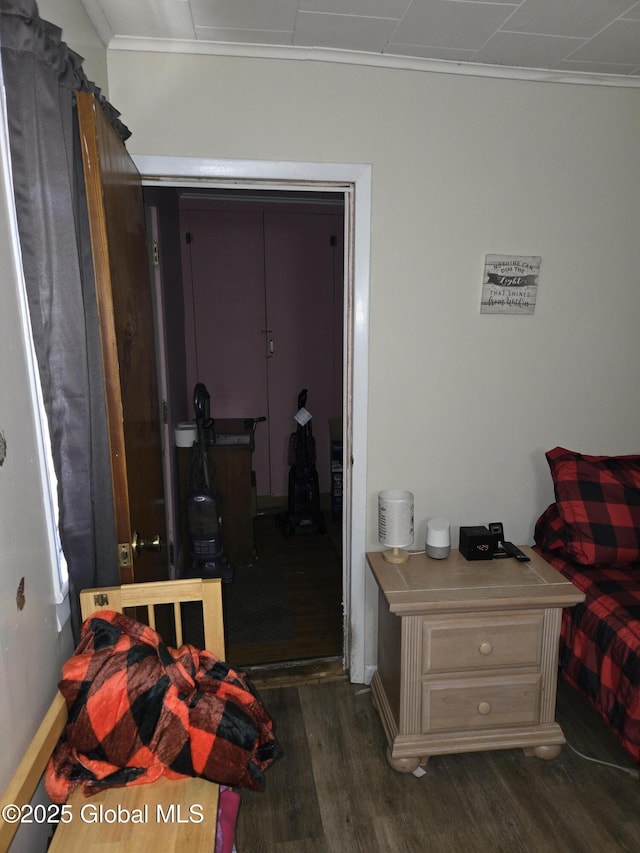 bedroom featuring dark wood-style floors, a closet, and crown molding