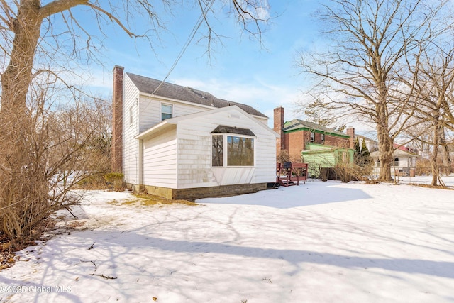 snow covered property featuring a chimney