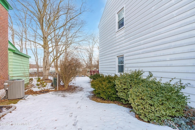 yard covered in snow featuring fence and central AC