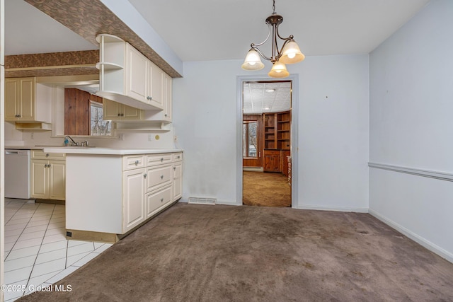 kitchen with white dishwasher, light colored carpet, baseboards, hanging light fixtures, and light countertops