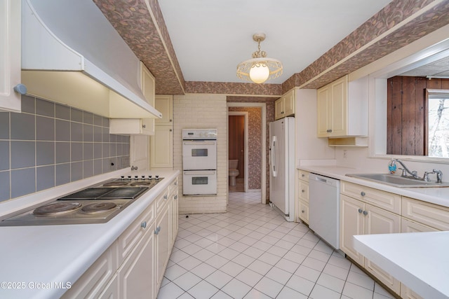 kitchen featuring light countertops, white appliances, a sink, and custom range hood