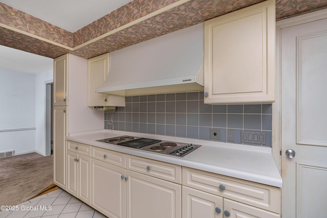 kitchen with decorative backsplash, black electric stovetop, custom exhaust hood, light countertops, and white cabinetry