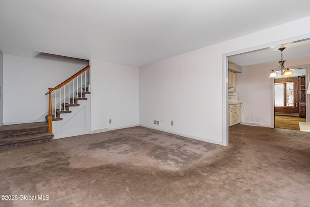 unfurnished living room featuring carpet floors, a baseboard heating unit, visible vents, and stairway