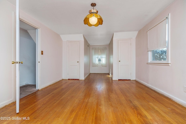 interior space featuring plenty of natural light, light wood-style flooring, and baseboards