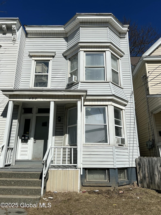 view of property with covered porch, fence, and cooling unit