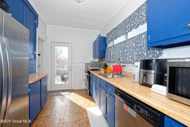 kitchen with blue cabinets, plenty of natural light, appliances with stainless steel finishes, and a sink