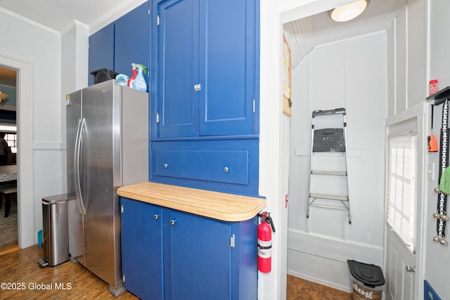 kitchen featuring blue cabinets, light countertops, crown molding, and freestanding refrigerator