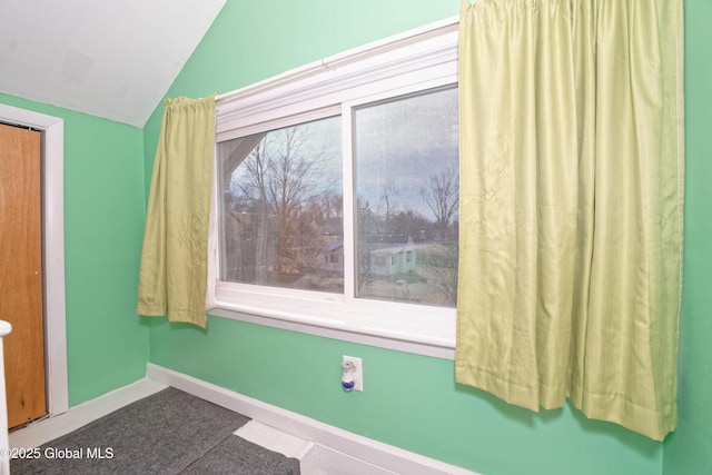 bathroom with vaulted ceiling and baseboards