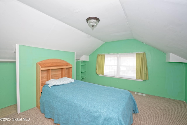 carpeted bedroom featuring lofted ceiling and visible vents