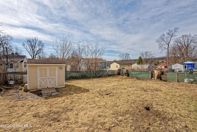 view of yard with a storage unit, a fenced backyard, and an outdoor structure