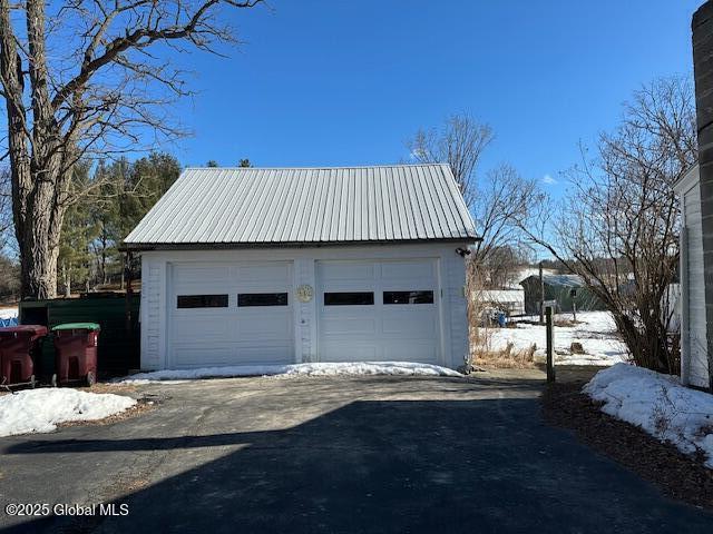 snow covered garage with a detached garage