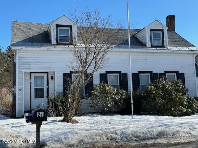 cape cod-style house featuring a chimney