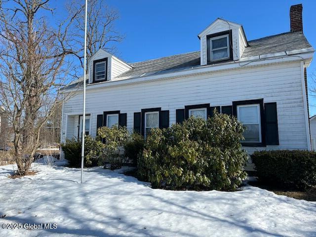 view of snowy exterior with a chimney