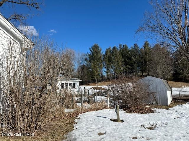 snowy yard featuring an outdoor structure