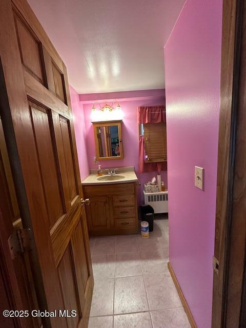 bathroom featuring radiator, vanity, and tile patterned flooring