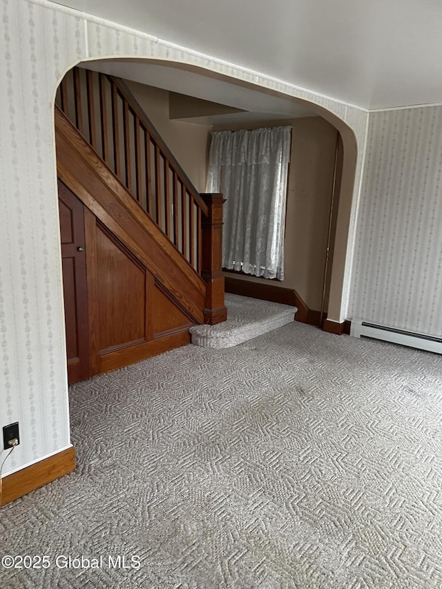 interior space with arched walkways, baseboards, wallpapered walls, and carpet