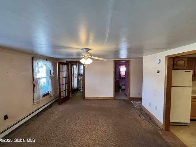 spare room with baseboards, light colored carpet, radiator heating unit, baseboard heating, and a ceiling fan