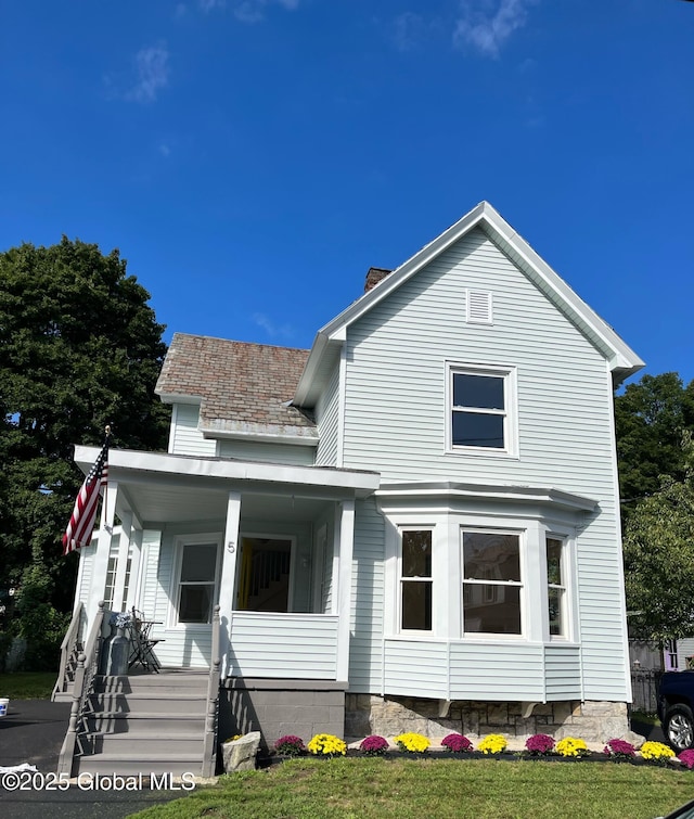 exterior space featuring covered porch and a chimney