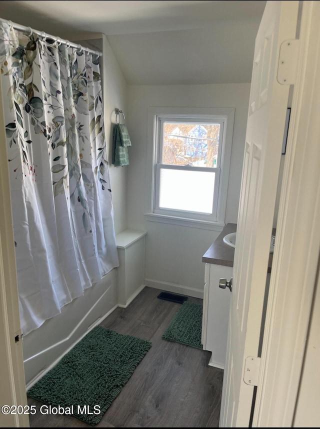 full bath with visible vents, baseboards, wood finished floors, shower / tub combo with curtain, and vanity