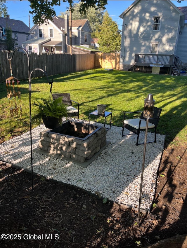 view of yard featuring fence, a fire pit, and a wooden deck