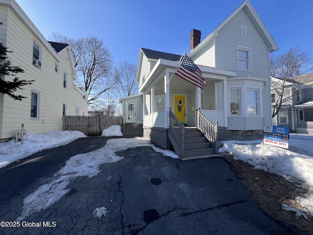 view of front of home featuring covered porch and a chimney