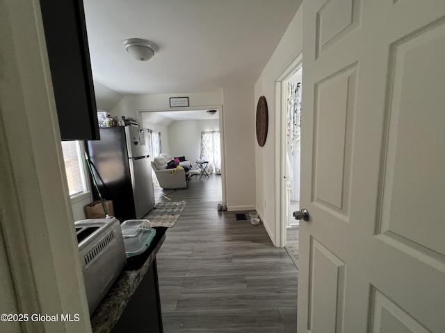 hallway featuring dark wood-type flooring and baseboards