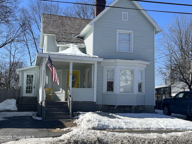 view of front of house with a chimney and a porch