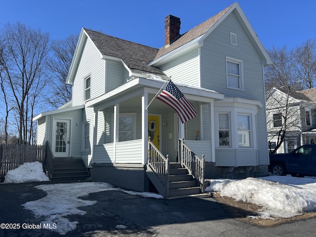 view of front facade featuring a porch and a chimney