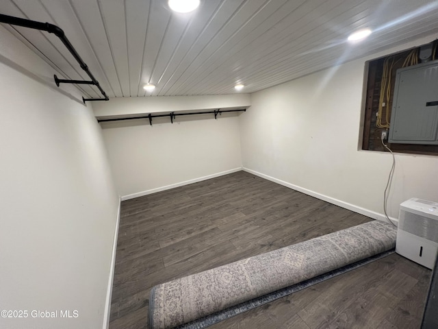 finished basement featuring electric panel, baseboards, wooden ceiling, wood finished floors, and recessed lighting